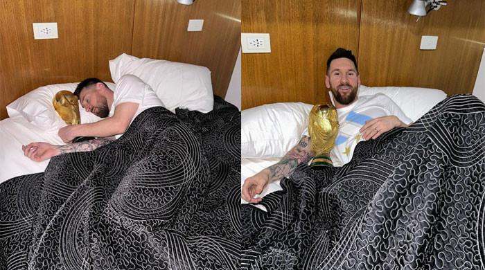 wc2022-the-world-cup-trophy-is-taken-to-bed-by-lionel-messi